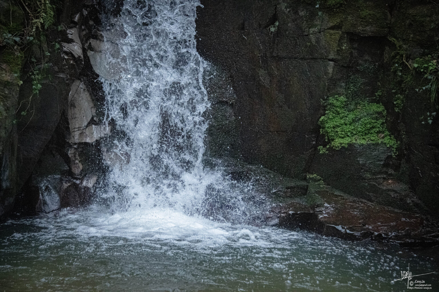 Aigua blanca de la cascada que esclata sobre una roca fosca, al Salt de Sant Martí.
